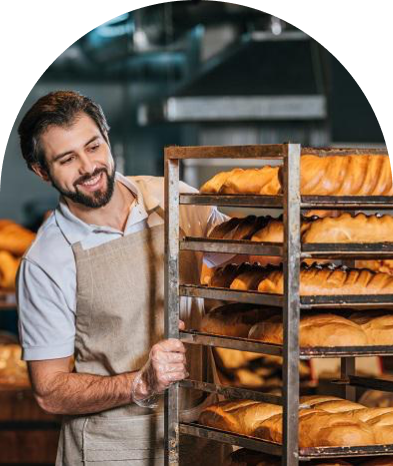 Чоловік пекар дивиться на батони із посмішкою